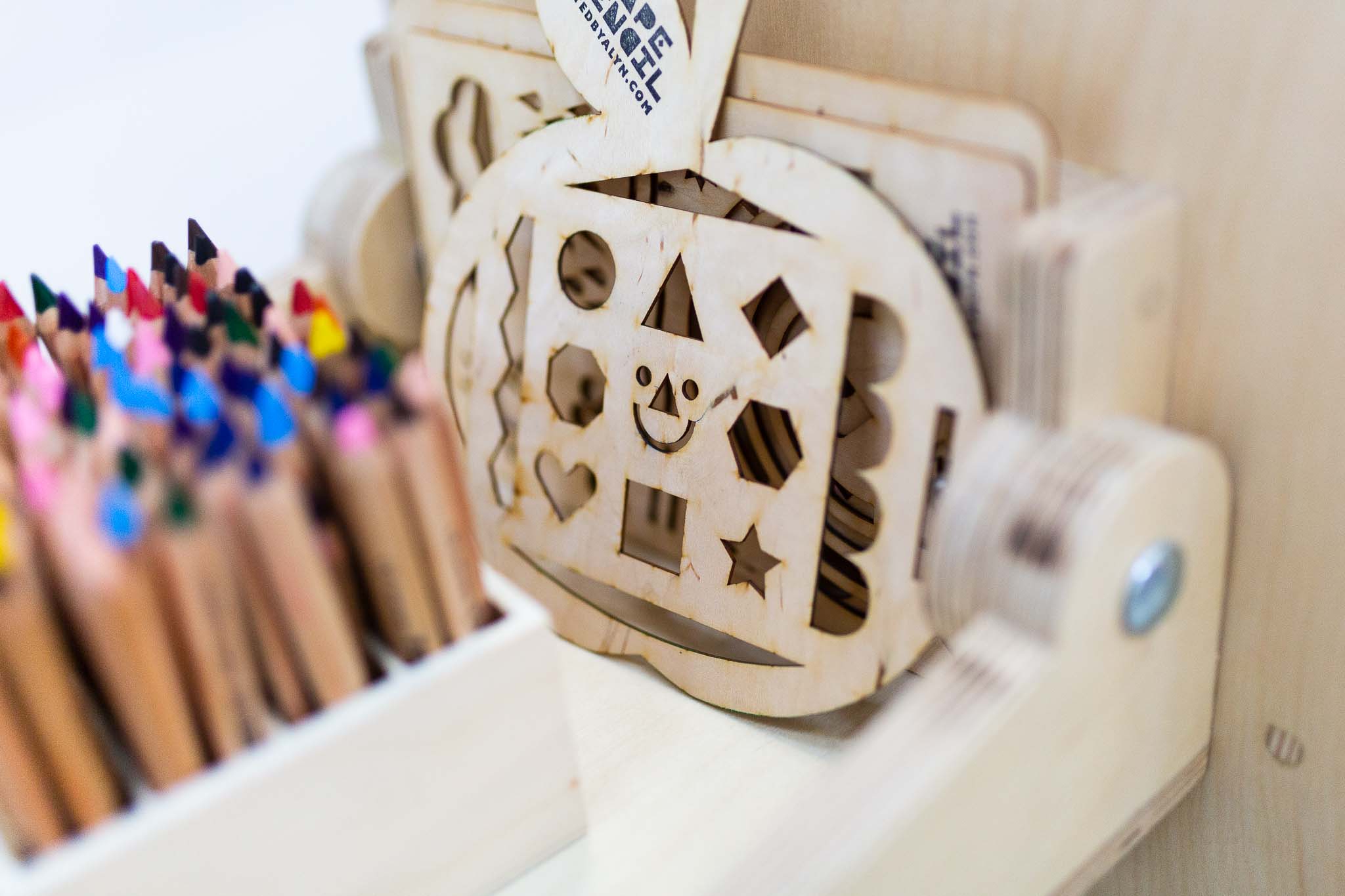A close up colour photograph of Arnold Art Cart at Arnolfini featuring a smiley face stencil and coloured pencils.
