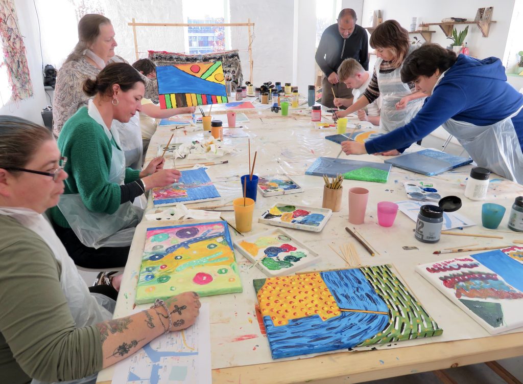 a colour photograph of AIM for Art School participants busy creating in the community workshop space at Arnolfini