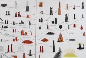 A photograph of an artwork called The Family Tree by David Nash. The image is of a work a pastel and charcoal drawing on paper. The drawing contains a number of small drawings of different sculptures and installations created by Nash. Black lines link different works together like a map. The small drawings are red, orange, yellow, brown, ash grey and black