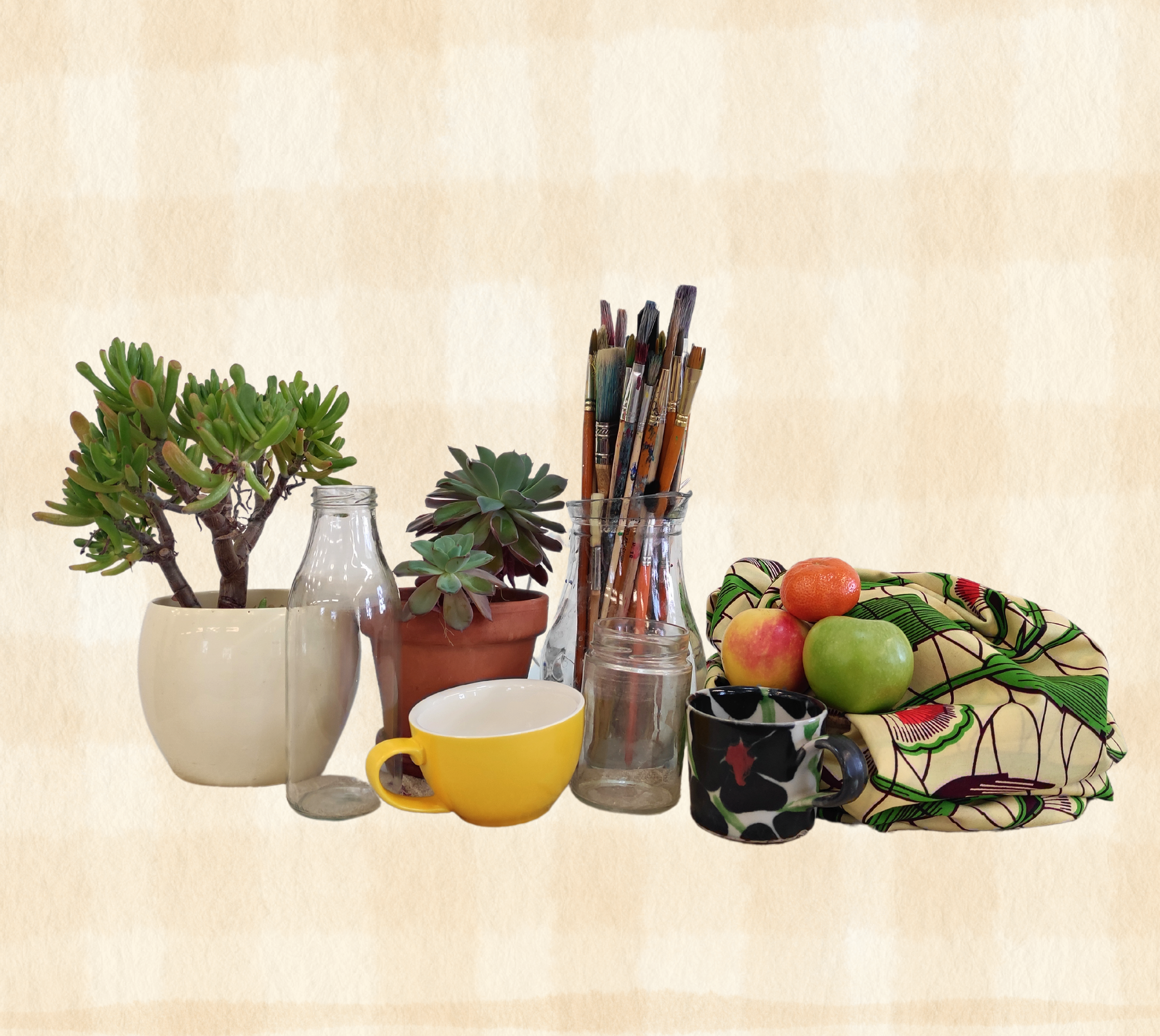 a collection of plants, cup and paintbrushes against a table cloth design background.s, fruit, bottles