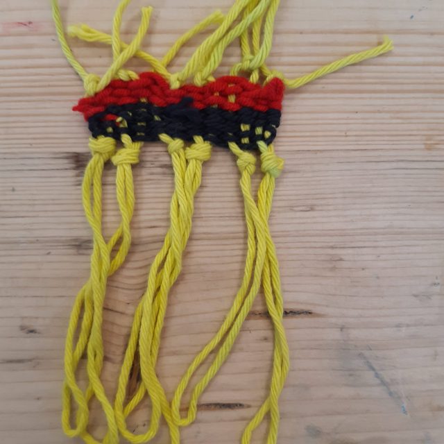 Weaved yarn in black, yellow and red.