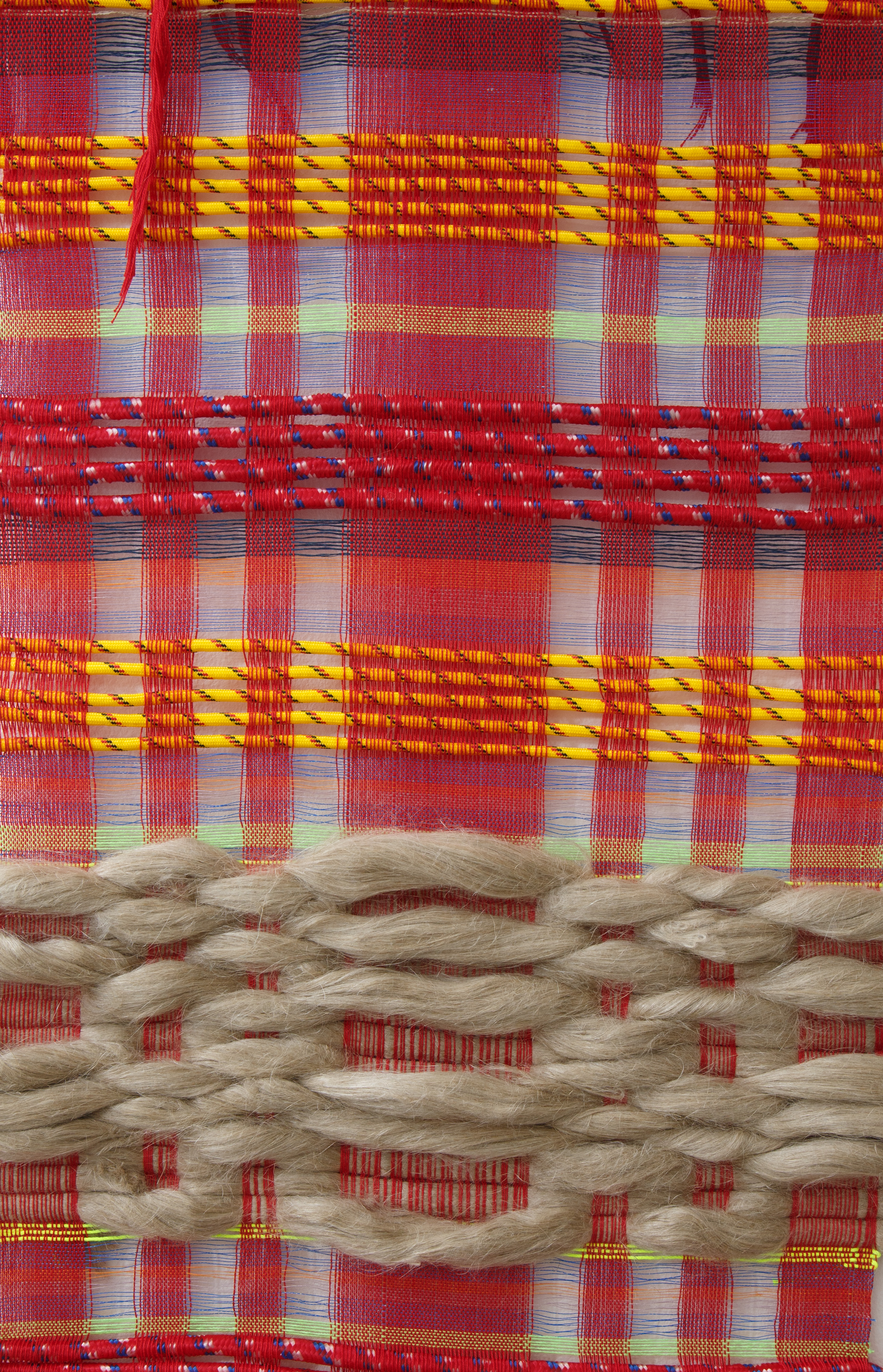 A close-up photograph of a woven artwork by Raisa Kabir titled Untitled I Flax. The top half of the work has a red, check pattern over which is woven yellow unspun flax and red cotton and in the bottom half the linen support is woven with brown industrial rope.