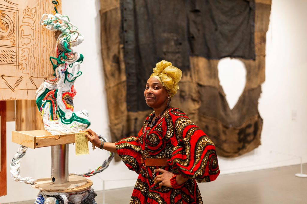 A colour photograph of artist Ifeoma U. Anyaeji in the gallery space at Arnolfini.