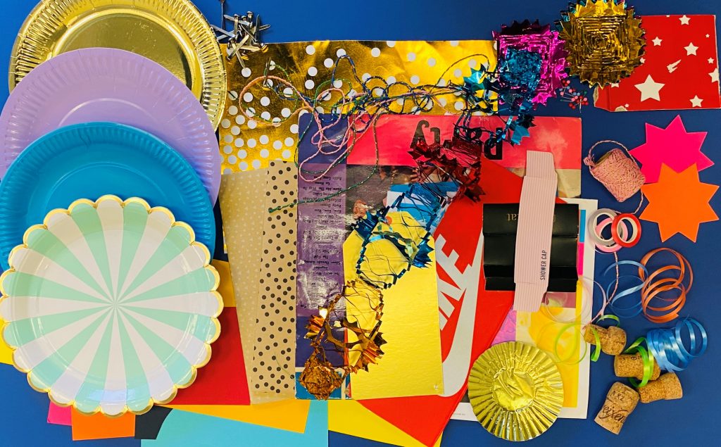 A coloured photograph of various bright coloured art material, flat laid and photographed.