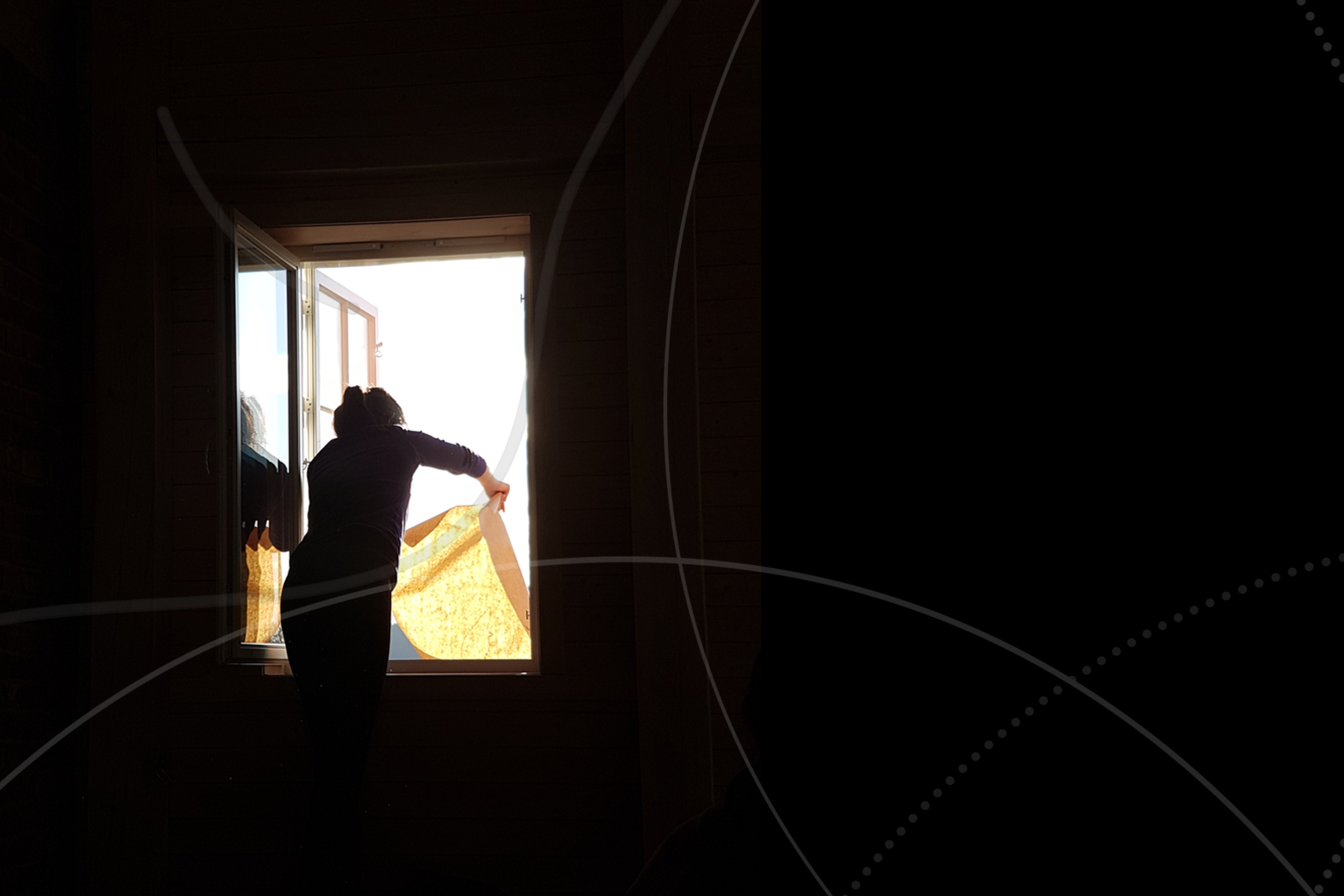 A woman in a darkened room, viewed from behind, shakes a cloth out of a window open to bright sunlight.